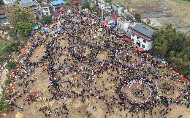 (251130) -- NANNING, Nov. 30, 2025 (Xinhua) -- An aerial drone photo taken on Feb. 13, 2025 shows local residents dancing to the accompaniment of Lusheng, a traditional reed-pipe wind instrument, in Rongshui Miao Autonomous County, south China's Guangxi Zhuang Autonomous Region. Rongshui County has leveraged its unique cultural resources of Lusheng to strengthen the inheritance of Miao ethnic culture and empower rural revitalization. (Photo by Zheng Changhao/Xinhua)
