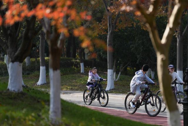 (251130) -- SHAOXING, Nov. 30, 2025 (Xinhua) -- People ride bikes at Didang lake scenic area in Shaoxing, east China's Zhejiang Province, Nov. 30, 2025. (Xinhua/Huang Zongzhi)