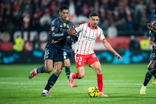 (251201) -- GIRONA, Dec. 1, 2025 (Xinhua) -- Jude Bellingham (L) of Real Madrid CF vies with Ivan Martin of Girona FC during the La Liga football match between Girona FC and Real Madrid CF in Montilivi Stadium, Girona, Spain, on Nov. 30, 2025. (Photo by Joan Gosa/Xinhua)