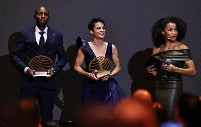 (251201) -- MONTE CARLO, Dec. 1, 2025 (Xinhua) -- Kenya's London Marathon and Berlin Marathon champion Sabastian Sawe (L) and Spain's world 20km and 35km race walk champion Maria Perez (C) receive their Men's and Women's out of stadium athlete of the year awards during the World Athletics Awards 2025 in Monte Carlo, Monaco, Nov. 30, 2025. (Xinhua/Gao Jing)