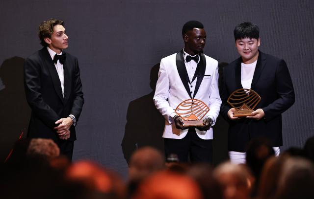 (251201) -- MONTE CARLO, Dec. 1, 2025 (Xinhua) -- Kenya's long distance and steeplechase athlete Edmund Serem (C) and China's hammer throw athlete Zhang Jiale (R) pose with their Men's and Women's rising star awards during the World Athletics Awards 2025 in Monte Carlo, Monaco, Nov. 30, 2025. (Xinhua/Gao Jing)