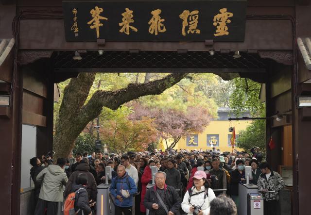 (251201) -- HANGZHOU, Dec. 1, 2025 (Xinhua) -- Tourists enter the Lingyin Feilai Peak Scenic Area in Hangzhou, east China's Zhejiang Province, Dec. 1, 2025. The Lingyin Feilai Peak Scenic Area in Hangzhou officially offers free admission from Monday. The entire scenic area including major cultural sites such as Lingyin Temple, Yongfu Temple and Taoguang Temple, are all for free entry. Visitors need to enter the scenic area with real-name reservation based on time slots. (Xinhua/Weng Xinyang)