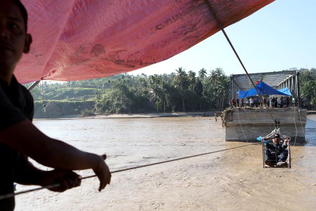 (251201) -- JAKARTA, Dec. 1, 2025 (Xinhua) -- This photo taken on Dec. 1, 2025 shows people crossing a river via a rope after a bridge was damaged by floodwaters in Bireuen Regency, Aceh Province, Indonesia. The death toll from recent floods and landslides across three provinces on Indonesia's Sumatra Island has risen to 502 with 508 missing, the National Disaster Management Agency (BNPB) said on Monday. (Photo by Fachrul Reza/Xinhua)