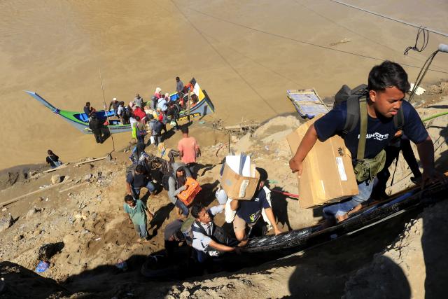 (251201) -- JAKARTA, Dec. 1, 2025 (Xinhua) -- This photo taken on Nov. 30, 2025 shows people crossing a river by boat after a bridge was damaged by floodwaters in Bireuen Regency, Aceh Province, Indonesia. The death toll from recent floods and landslides across three provinces on Indonesia's Sumatra Island has risen to 502 with 508 missing, the National Disaster Management Agency (BNPB) said on Monday. (Photo by Yulham/Xinhua)