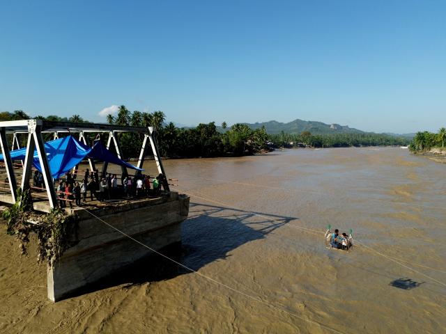 (251201) -- JAKARTA, Dec. 1, 2025 (Xinhua) -- A drone photo taken on Dec. 1, 2025 shows people crossing a river via a rope after a bridge was damaged by floodwaters in Bireuen Regency, Aceh Province, Indonesia. The death toll from recent floods and landslides across three provinces on Indonesia's Sumatra Island has risen to 502 with 508 missing, the National Disaster Management Agency (BNPB) said on Monday. (Photo by Fachrul Reza/Xinhua)