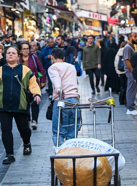 (251201) -- ISTANBUL, Dec. 1, 2025 (Xinhua) -- A porter transports goods with a handcart near the Grand Bazaar in Istanbul, Türkiye, Nov. 24, 2025. In the old quarters of Istanbul, one often encounters a familiar scene: men weaving through narrow streets, carrying heavy loads on their backs or pushing them on handcarts. Known in Turkish as "hamal," these traditional porters represent a profession that dates back to the Ottoman era and endures to this day.
   The porters'tools are simple -- a thick shoulder strap or a sturdy handcart. Dozens of kilograms, sometimes even loads exceeding a hundred kilograms, are lifted and transported with steady precision before disappearing into the maze-like streets.
   The Grand Bazaar, the Spice Bazaar, and the commercial district of Eminonu are among Istanbul's oldest and busiest trading hubs. Dense shopfronts, heavy foot traffic, and a network of narrow alleys and intersections leave little room for motor vehicles, which have allowed the hamal profession to survive and remain indispensable.
   In these labyrinthine streets, they shoulder countless small-scale logistics tasks, quietly sustaining the commercial lifeblood of the city. In Istanbul, being a porter is not only a traditional craft -- it is a foundational force that has supported the city's commercial vitality for centuries. (Xinhua/Liu Lei)