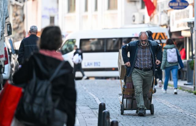 (251201) -- ISTANBUL, Dec. 1, 2025 (Xinhua) -- A porter transports goods with a handcart in the Eminonu commercial district of Istanbul, Türkiye, Nov. 25, 2025. In the old quarters of Istanbul, one often encounters a familiar scene: men weaving through narrow streets, carrying heavy loads on their backs or pushing them on handcarts. Known in Turkish as "hamal," these traditional porters represent a profession that dates back to the Ottoman era and endures to this day.
   The porters'tools are simple -- a thick shoulder strap or a sturdy handcart. Dozens of kilograms, sometimes even loads exceeding a hundred kilograms, are lifted and transported with steady precision before disappearing into the maze-like streets.
   The Grand Bazaar, the Spice Bazaar, and the commercial district of Eminonu are among Istanbul's oldest and busiest trading hubs. Dense shopfronts, heavy foot traffic, and a network of narrow alleys and intersections leave little room for motor vehicles, which have allowed the hamal profession to survive and remain indispensable.
   In these labyrinthine streets, they shoulder countless small-scale logistics tasks, quietly sustaining the commercial lifeblood of the city. In Istanbul, being a porter is not only a traditional craft -- it is a foundational force that has supported the city's commercial vitality for centuries. (Xinhua/Liu Lei)