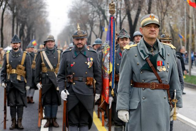 (251201) -- BUCHAREST, Dec. 1, 2025 (Xinhua) -- People wearing vintage military uniforms attend a military parade celebrating Romania's National Day in Bucharest, Romania, on Dec. 1, 2025. (Photo by Cristian Cristel/Xinhua)