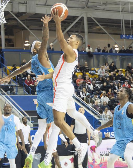 (251202) -- TORONTO, Dec. 2, 2025 (Xinhua) -- Trae Bell-Haynes (top R) of Canada goes up for a layup during the first round group match of the FIBA Basketball World Cup 2027 Americas Qualifiers between Canada and Bahamas in Toronto, Canada, on Dec. 1, 2025. (Photo by Zou Zheng/Xinhua)