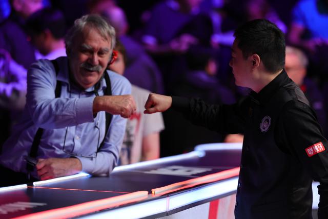 (251202) -- YORK, Dec. 2, 2025 (Xinhua) -- Ding Junhui (R) of China interacts with a fan after winning the first round match against Xu Si of China at the 2025 UK Snooker Championship in York, Britain, Dec. 1, 2025. (Photo by Zhai Zheng/Xinhua)