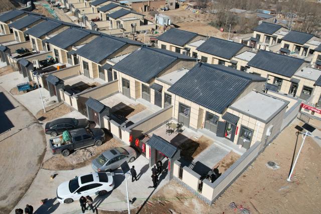 (251202) -- YUZHONG, Dec. 2, 2025 (Xinhua) -- An aerial drone photo taken on Dec. 1, 2025 shows a flood-affected household moving into their new home at a resettlement site in Maliantan Village of Mapo Town in Yuzhong County, northwest China's Gansu Province. Yuzhong County, which is under the jurisdiction of the provincial capital Lanzhou, was hit by mountain torrents triggered by torrential rains this August. According to a reconstruction plan made by the local government, six resettlement sites for 325 families are on construction smoothly. 
Currently, the supporting facilities as well as indoor and outdoor decorations at these resettlement sites are almost finished, waiting for check upon delivery. Disaster-affected people are moving into new homes in batches. (Xinhua/Chen Bin)