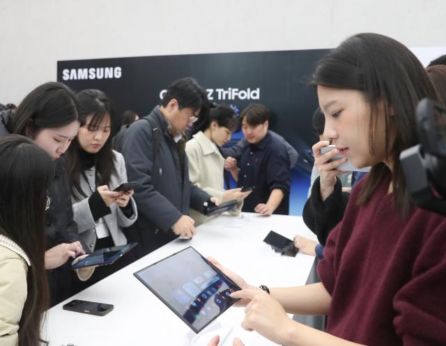 (251202) -- SEOUL, Dec. 2, 2025 (Xinhua) -- Journalists try Samsung Electronics' newly launched tri-fold smartphone in Seoul, South Korea, on Dec. 2, 2025. Samsung Electronics held a press conference Tuesday in Seoul, unveiling its latest tri-fold smartphone. (Xinhua/Yao Qilin)