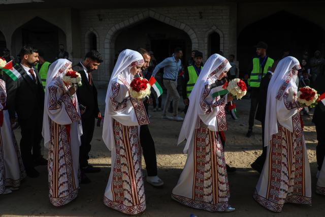 (251202) -- GAZA, Dec. 2, 2025 (Xinhua) -- Palestinian grooms and brides celebrate together a mass wedding in the southern Gaza Strip city of Khan Younis, Dec. 2, 2025. Fifty-four couples attended the event. (Photo by Rizek Abdeljawad/Xinhua)