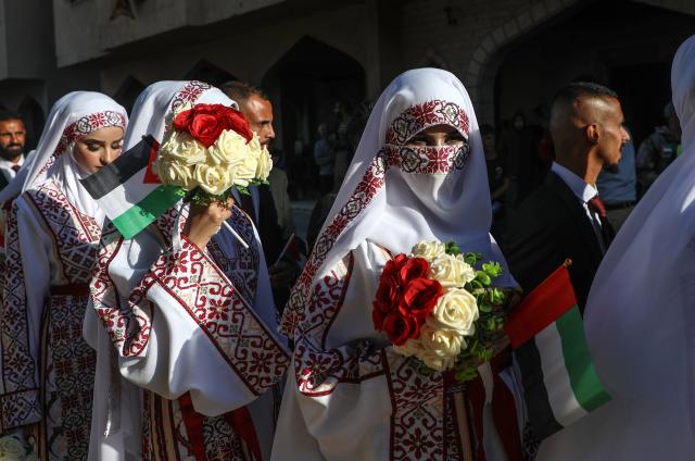 (251202) -- GAZA, Dec. 2, 2025 (Xinhua) -- Palestinian grooms and brides celebrate together a mass wedding in the southern Gaza Strip city of Khan Younis, Dec. 2, 2025. Fifty-four couples attended the event. (Photo by Rizek Abdeljawad/Xinhua)