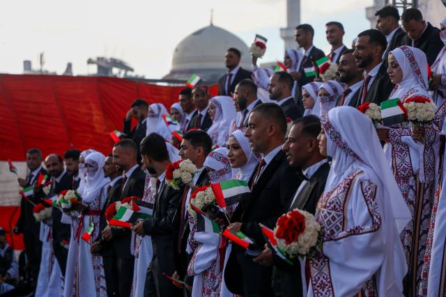 (251202) -- GAZA, Dec. 2, 2025 (Xinhua) -- Palestinian grooms and brides celebrate together a mass wedding in the southern Gaza Strip city of Khan Younis, Dec. 2, 2025. Fifty-four couples attended the event. (Photo by Rizek Abdeljawad/Xinhua)