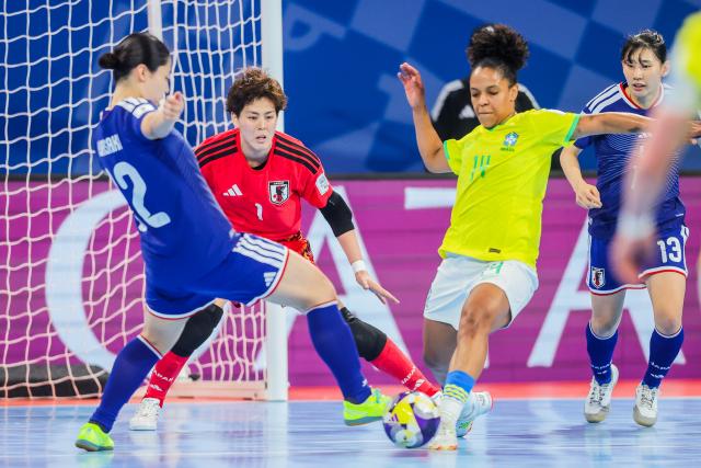 (251203) -- PASIG CITY, Dec. 3, 2025 (Xinhua) -- Ana Luiza (2nd R) of Brazil vies for the ball during the quarterfinal match between Brazil and Japan at the FIFA Futsal Women's World Cup 2025 in Pasig City, the Philippines, on Dec. 2, 2025. (Xinhua/Rouelle Umali)