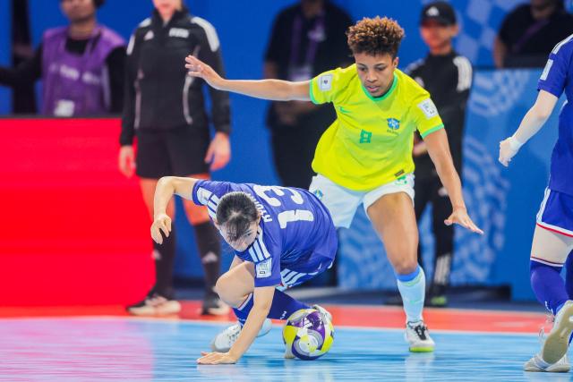 (251203) -- PASIG CITY, Dec. 3, 2025 (Xinhua) -- Luana Rodrigues (R) of Brazil competes against Takahashi Kyoka of Japan during the quarterfinal match between Brazil and Japan at the FIFA Futsal Women's World Cup 2025 in Pasig City, the Philippines, on Dec. 2, 2025. (Xinhua/Rouelle Umali)