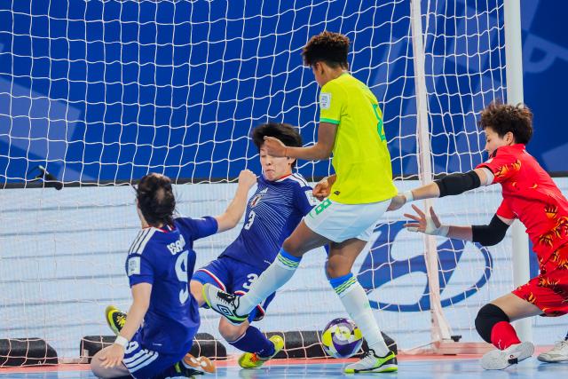 (251203) -- PASIG CITY, Dec. 3, 2025 (Xinhua) -- Luana Rodrigues (2nd R) of Brazil shoots and scores during the quarterfinal match between Brazil and Japan at the FIFA Futsal Women's World Cup 2025 in Pasig City, the Philippines, on Dec. 2, 2025. (Xinhua/Rouelle Umali)