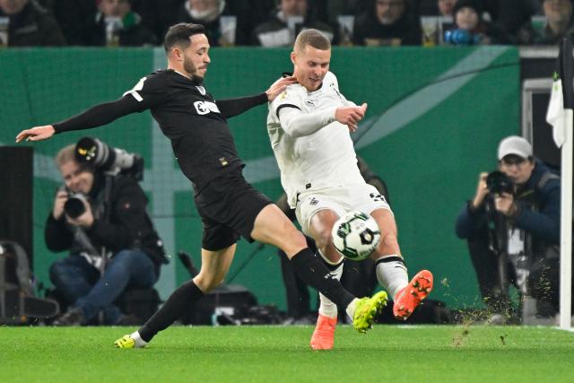 (251203) -- MOENCHENGLADBACH, Dec. 3, 2025 (Xinhua) -- Nico Elvedi (R) of Borussia Moenchengladbach vies with James Sands of FC St. Pauli during the German Cup football round of 16 match between Borussia Moenchengladbach and FC St. Pauli in Moenchengladbach, Germany, Dec. 2, 2025. (Photo by Ulrich Hufnagel/Xinhua)