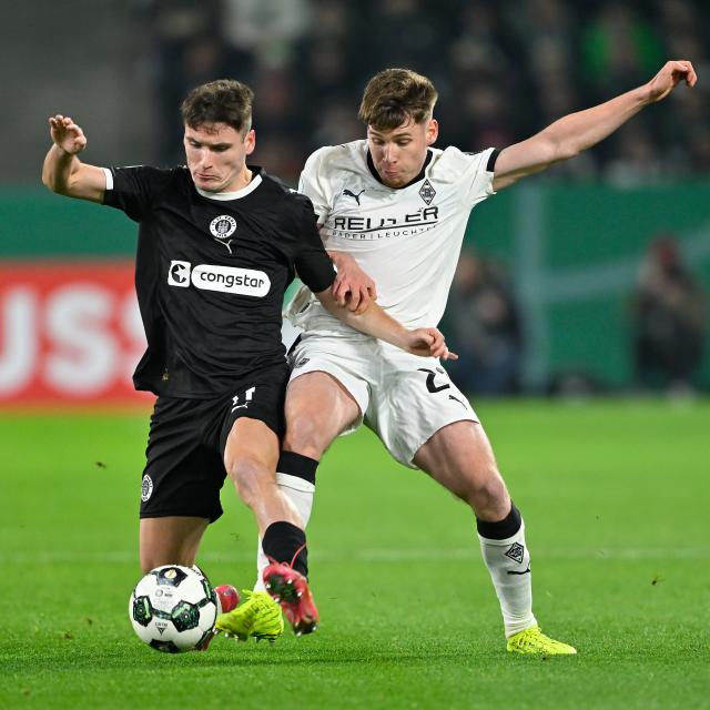 (251203) -- MOENCHENGLADBACH, Dec. 3, 2025 (Xinhua) -- Lukas Ullrich (R) of Borussia Moenchengladbach vies with Arkadiusz Pyrka of FC St. Pauli during the German Cup football round of 16 match between Borussia Moenchengladbach and FC St. Pauli in Moenchengladbach, Germany, Dec. 2, 2025. (Photo by Ulrich Hufnagel/Xinhua)