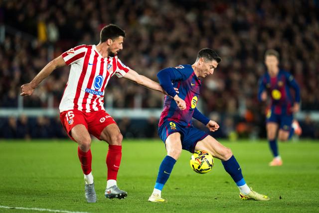(251203) -- BARCELONA, Dec. 3, 2025 (Xinhua) -- Robert Lewandowski (R) of Barcelona vies with Clement Lenglet of Atletico de Madrid during the La Liga football match between FC Barcelona and Atletico de Madrid in Barcelona, Spain, on Dec. 3, 2025. (Photo by Joan Gosa/Xinhua)