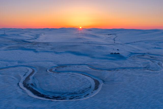 (251203) -- HULUN BUIR, Dec. 3, 2025 (Xinhua) -- An aerial drone photo taken on Dec. 3, 2025 shows the sunrise scenery on the snow-covered Chenbarhu Banner Grassland in Hulun Buir, north China's Inner Mongolia Autonomous Region. (Xinhua/Darhan)