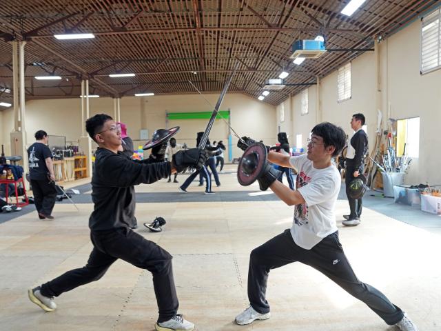 (251203) -- SHANGHAI, Dec. 3, 2025 (Xinhua) -- Members of the Shanghai Historical Martial Arts (SHMA) club practice with each other at the SHMA in Shanghai, east China, Nov. 22, 2025. Ismet Himmet, with his Chinese name You Lihan, speaks fluent Chinese and has devoted more than thirty years to Chinese martial arts. Himmet, now 48, began learning kung fu in 1991. Nine years later, he traveled to China for the first time. From 2006 he started teaching Chinese martial arts full-time in Germany. At XUAN-Gong Fu Academy, a kung fu school that Himmet established in Berlin, students of all ages practise Tai Chi, Ba Gua Zhang, Xingyiquan and other kung fu styles every day. In his view, martial arts are not just a sport, but also a way of living and something that helps the mind turn toward the positive.
  Thousands of kilometers away, in east China's Shanghai, She Yuran, known as "A Xiao", is engaged in a similar career as Himmet. Born in Sichuan of China, She Yuran studied Historical European Martial Arts (HEMA) at college. His interest in HEMA grew into a deep study of historical weapons and combat methods.
  In 2015, She Yuran co-founded the Shanghai Historical Martial Arts (SHMA) club, offering systematic training in both European and Chinese martial arts. SHMA now has more than 200 members, over half of whom study German swordsmanship. 
  While Ismet Himmet helps Germans understand the philosophy and practice of Chinese martial arts, She Yuran brings European sword traditions to young Chinese practitioners. Their commitment shows how martial arts can carry culture across borders, allowing mutual understanding to grow through their fists and blades. (Xinhua/Liu Ying)