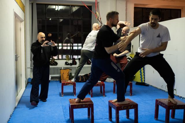 (251203) -- BERLIN, Dec. 3, 2025 (Xinhua) -- Ismet Himmet (1st L) records students practicing at XUAN-Gong Fu Academy in Berlin, Germany, Nov. 13, 2025. Ismet Himmet, with his Chinese name You Lihan, speaks fluent Chinese and has devoted more than thirty years to Chinese martial arts. Himmet, now 48, began learning kung fu in 1991. Nine years later, he traveled to China for the first time. From 2006 he started teaching Chinese martial arts full-time in Germany. At XUAN-Gong Fu Academy, a kung fu school that Himmet established in Berlin, students of all ages practise Tai Chi, Ba Gua Zhang, Xingyiquan and other kung fu styles every day. In his view, martial arts are not just a sport, but also a way of living and something that helps the mind turn toward the positive.
  Thousands of kilometers away, in east China's Shanghai, She Yuran, known as "A Xiao", is engaged in a similar career as Himmet. Born in Sichuan of China, She Yuran studied Historical European Martial Arts (HEMA) at college. His interest in HEMA grew into a deep study of historical weapons and combat methods.
  In 2015, She Yuran co-founded the Shanghai Historical Martial Arts (SHMA) club, offering systematic training in both European and Chinese martial arts. SHMA now has more than 200 members, over half of whom study German swordsmanship. 
  While Ismet Himmet helps Germans understand the philosophy and practice of Chinese martial arts, She Yuran brings European sword traditions to young Chinese practitioners. Their commitment shows how martial arts can carry culture across borders, allowing mutual understanding to grow through their fists and blades. (Xinhua/Zhang Haofu)