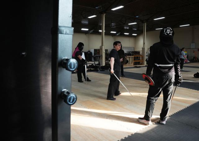 (251203) -- SHANGHAI, Dec. 3, 2025 (Xinhua) -- This photo shows a scene on a sword and shield course at the Shanghai Historical Martial Arts (SHMA) club in Shanghai, east China, Nov. 22, 2025. Ismet Himmet, with his Chinese name You Lihan, speaks fluent Chinese and has devoted more than thirty years to Chinese martial arts. Himmet, now 48, began learning kung fu in 1991. Nine years later, he traveled to China for the first time. From 2006 he started teaching Chinese martial arts full-time in Germany. At XUAN-Gong Fu Academy, a kung fu school that Himmet established in Berlin, students of all ages practise Tai Chi, Ba Gua Zhang, Xingyiquan and other kung fu styles every day. In his view, martial arts are not just a sport, but also a way of living and something that helps the mind turn toward the positive.
  Thousands of kilometers away, in east China's Shanghai, She Yuran, known as "A Xiao", is engaged in a similar career as Himmet. Born in Sichuan of China, She Yuran studied Historical European Martial Arts (HEMA) at college. His interest in HEMA grew into a deep study of historical weapons and combat methods.
  In 2015, She Yuran co-founded the Shanghai Historical Martial Arts (SHMA) club, offering systematic training in both European and Chinese martial arts. SHMA now has more than 200 members, over half of whom study German swordsmanship. 
  While Ismet Himmet helps Germans understand the philosophy and practice of Chinese martial arts, She Yuran brings European sword traditions to young Chinese practitioners. Their commitment shows how martial arts can carry culture across borders, allowing mutual understanding to grow through their fists and blades. (Xinhua/Liu Ying)