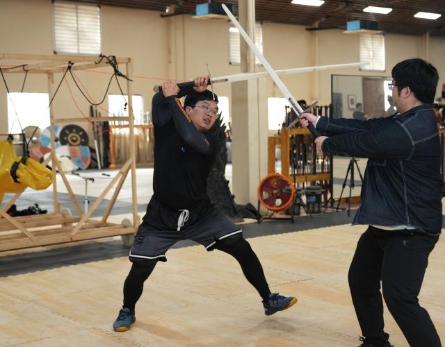 (251203) -- SHANGHAI, Dec. 3, 2025 (Xinhua) -- She Yuran (L) teaches a student at the Shanghai Historical Martial Arts (SHMA) club in Shanghai, east China, Nov. 22, 2025. Ismet Himmet, with his Chinese name You Lihan, speaks fluent Chinese and has devoted more than thirty years to Chinese martial arts. Himmet, now 48, began learning kung fu in 1991. Nine years later, he traveled to China for the first time. From 2006 he started teaching Chinese martial arts full-time in Germany. At XUAN-Gong Fu Academy, a kung fu school that Himmet established in Berlin, students of all ages practise Tai Chi, Ba Gua Zhang, Xingyiquan and other kung fu styles every day. In his view, martial arts are not just a sport, but also a way of living and something that helps the mind turn toward the positive.
  Thousands of kilometers away, in east China's Shanghai, She Yuran, known as "A Xiao", is engaged in a similar career as Himmet. Born in Sichuan of China, She Yuran studied Historical European Martial Arts (HEMA) at college. His interest in HEMA grew into a deep study of historical weapons and combat methods.
  In 2015, She Yuran co-founded the Shanghai Historical Martial Arts (SHMA) club, offering systematic training in both European and Chinese martial arts. SHMA now has more than 200 members, over half of whom study German swordsmanship. 
  While Ismet Himmet helps Germans understand the philosophy and practice of Chinese martial arts, She Yuran brings European sword traditions to young Chinese practitioners. Their commitment shows how martial arts can carry culture across borders, allowing mutual understanding to grow through their fists and blades. (Xinhua/Liu Ying)