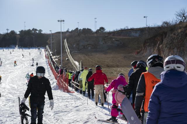 (251203) -- TIANJIN, Dec. 3, 2025 (Xinhua) -- People take a "magic carpet" escalator at a ski resort in Jizhou District, north China's Tianjin, Dec. 2, 2025. In recent years, authorities in Jizhou District of Tianjin, which sits on the east section of the Yanshan Mountain, have been boosting ice and snow tourism by exploring local resources and improving service infrastructure. (Xinhua/Fu Tian)