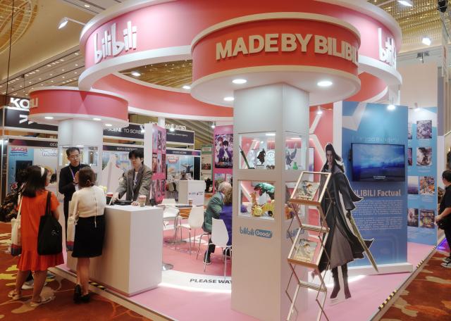 (251203) -- SINGAPORE, Dec. 3, 2025 (Xinhua) -- People visit a booth of Chinese exhibitor Bilibili at the 26th Asia TV Forum and Market (ATF) held in Singapore on Dec. 3, 2025. China mounted its largest presence to date at the 26th ATF as the event held its opening ceremony on Wednesday, drawing strong interest from buyers and producers worldwide.
  The China Pavilion has expanded to 270 square meters this year, with 24 participating companies, both record highs. The pavilion is showcasing 156 Chinese-language titles, spanning TV series, micro dramas, films, documentaries, animation and variety shows. (Photo by Then Chih Wey/Xinhua)