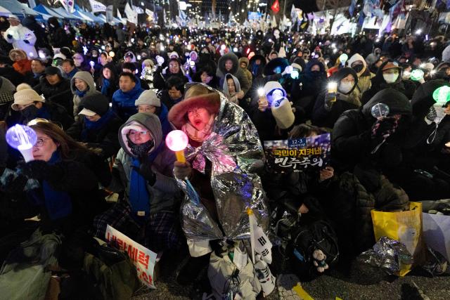 (251203) -- SEOUL, Dec. 3, 2025 (Xinhua) -- People gather near the National Assembly in Seoul, South Korea, on Dec. 3, 2025. South Korean President Lee Jae Myung said Wednesday that his government will designate Dec. 3 as People's Sovereignty Day to mark the overcoming of the martial law crisis. (Photo by Jun Hyosang/Xinhua)
