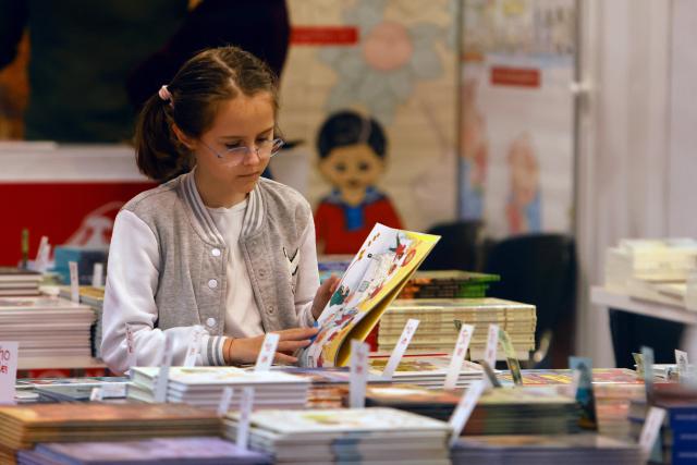 (251203) -- BUCHAREST, Dec. 3, 2025 (Xinhua) -- A child looks at a book during the opening day of the 32nd edition Gaudeamus Book Fair in Bucharest, Romania, Dec. 3, 2025. (Photo by Cristian Cristel/Xinhua)