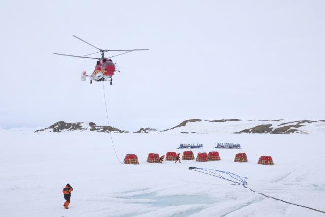 (251204) -- BEIJING, Dec. 4, 2025 (Xinhua) -- A helicopter transfers fuel bladders during China's 42nd Antarctic expedition operations near Zhongshan Station, a Chinese research base in Antarctica, on Dec. 2, 2025. (Xinhua/Gu Tiancheng)