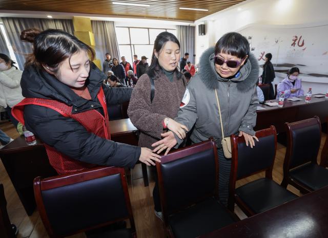 (251204) -- JIAXING, Dec. 4, 2025 (Xinhua) -- A volunteer guides visually-impaired audience to find their seats at a cinema in Jiaxing, east China's Zhejiang Province, Dec. 3, 2025. Wednesday marks the 34th International Day of Persons with Disabilities. Visually-impaired people enjoyed a barrier-free version of the movie "One and Only" here in Nanhu District of Jiaxing. The activity was under the Cinema of Light, a volunteer project initiated by faculty and students of the Communication University of China (CUC) in 2017 to produce films with voice descriptions of the visual content. (Xinhua/Xu Yu)