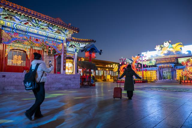 (251204) -- TIANJIN, Dec. 4, 2025 (Xinhua) -- A tourist takes pictures at Yangliuqing ancient town in Tianjin, north China, on Dec. 3, 2025. Sitting on the outskirts of the port city of Tianjin, Yangliuqing ancient town is a tourist town that is well-known for its woodblock new year pictures. It is run through by the Grand Canal, the world's longest man-made waterway. (Xinhua/Fu Tian)