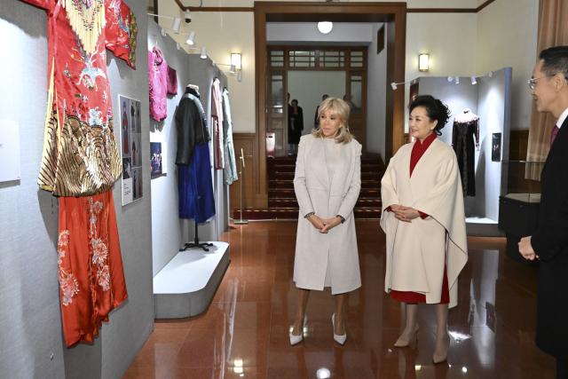 (251204) -- BEIJING, Dec. 4, 2025 (Xinhua) -- Peng Liyuan, wife of Chinese President Xi Jinping, and Brigitte Macron, wife of French President Emmanuel Macron, visit the Beijing People's Art Theatre in Beijing, capital of China, Dec. 4, 2025. Brigitte is accompanying the French president on his state visit to China. (Xinhua/Li Xiang)