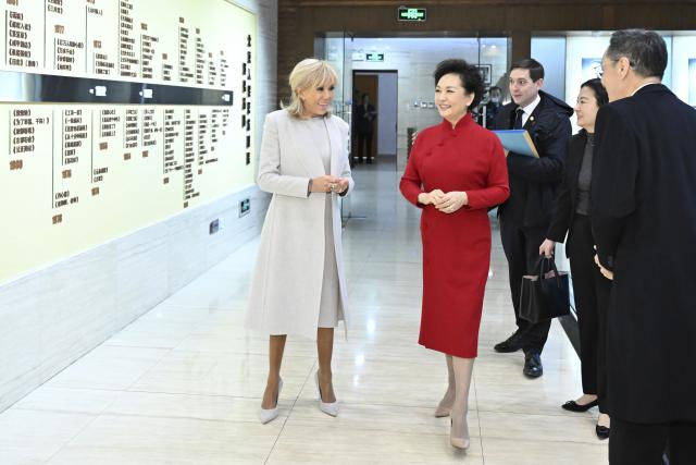 (251204) -- BEIJING, Dec. 4, 2025 (Xinhua) -- Peng Liyuan, wife of Chinese President Xi Jinping, and Brigitte Macron, wife of French President Emmanuel Macron, visit the Beijing People's Art Theatre in Beijing, capital of China, Dec. 4, 2025. Brigitte is accompanying the French president on his state visit to China. (Xinhua/Li Xiang)
