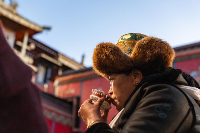 (251204) -- LHASA, Dec. 4, 2025 (Xinhua) -- A woman drinks a cup of barley wine at Jokhang Temple in Lhasa, southwest China's Xizang Autonomous Region, Dec. 4, 2025. Xizang marked the annual Fairy's Day, also known as the "Women's Festival", on Thursday, the 15th day of the tenth month in the Tibetan calendar. Women in festive attire were seen on the streets carrying hada scarves and barley wine as they headed to Jokhang Temple to pay homage to Palden Lhamo, a goddess in Tibetan Buddhism. (Xinhua/Tenzin Nyida)