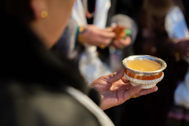 (251204) -- LHASA, Dec. 4, 2025 (Xinhua) -- A woman holds a cup of barley wine at Jokhang Temple in Lhasa, southwest China's Xizang Autonomous Region, Dec. 4, 2025. Xizang marked the annual Fairy's Day, also known as the "Women's Festival", on Thursday, the 15th day of the tenth month in the Tibetan calendar. Women in festive attire were seen on the streets carrying hada scarves and barley wine as they headed to Jokhang Temple to pay homage to Palden Lhamo, a goddess in Tibetan Buddhism. (Xinhua/Tenzing Nima Qadhup)