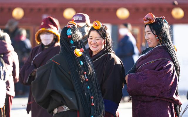 (251204) -- LHASA, Dec. 4, 2025 (Xinhua) -- Women in festive attire talk to each other on Barkhor Street in Lhasa, southwest China's Xizang Autonomous Region, Dec. 4, 2025. Xizang marked the annual Fairy's Day, also known as the "Women's Festival", on Thursday, the 15th day of the tenth month in the Tibetan calendar. Women in festive attire were seen on the streets carrying hada scarves and barley wine as they headed to Jokhang Temple to pay homage to Palden Lhamo, a goddess in Tibetan Buddhism. (Xinhua/Tenzin Nyida)