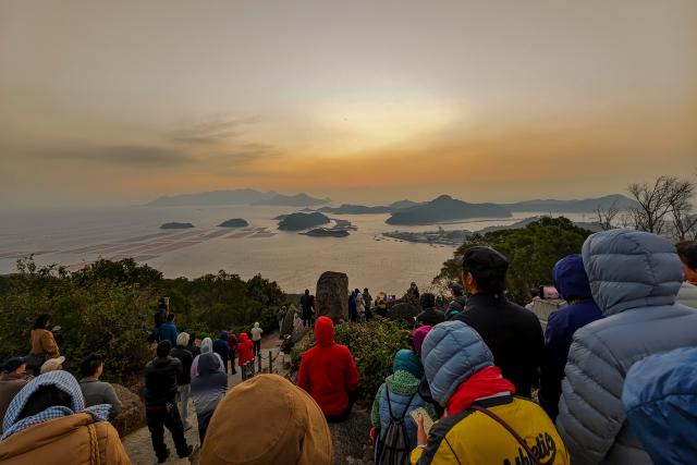 (251204) -- XIAPU, Dec. 4, 2025 (Xinhua) -- Photography enthusiasts watch and capture sea views at sunrise in Huazhu Village, Sansha Town, Xiapu County, southeast China's Fujian Province, Dec. 4, 2025. Sansha Town in Xiapu County, blessed with unique natural resources and rich historical culture, has been walking a distinctive path to rural revitalization by orchestrating tourist attractions such as high-end homestays, tidal flat landscape and local specialty food with rural development. (Xinhua/Wei Peiquan)