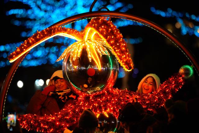 (251204) -- WARSAW, Dec. 4, 2025 (Xinhua) -- Visitors are seen next to a holiday light installation in the Old Town in Warsaw, Poland, Dec. 3, 2025. Christmas decorations bring strong festive vibe to the city. (Photo by Jaap Arriens/Xinhua)