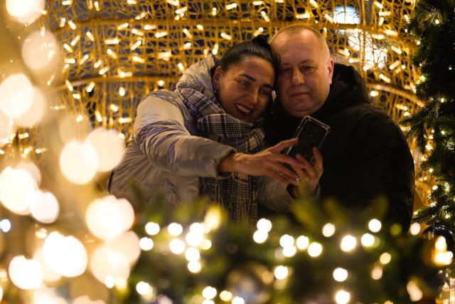 (251204) -- WARSAW, Dec. 4, 2025 (Xinhua) -- Visitors take a selfie in the Old Town in Warsaw, Poland, Dec. 3, 2025. Christmas decorations bring strong festive vibe to the city. (Photo by Jaap Arriens/Xinhua)