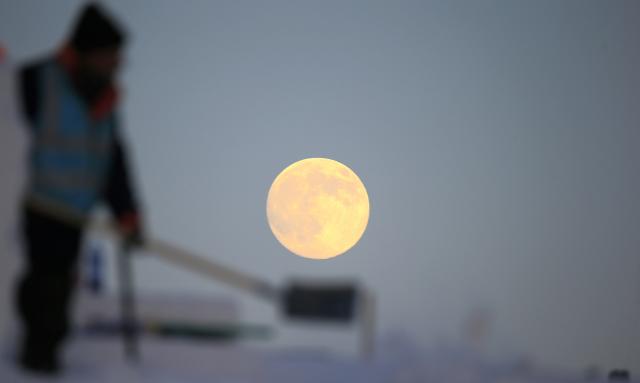 (251204) -- BEIJING, Dec. 4, 2025 (Xinhua) -- A full moon is pictured at the construction site of the Sun Island International Snow Sculpture Art Expo park in Harbin, northeast China's Heilongjiang Province, Dec. 4, 2025. This year's second-largest full moon to the eyes of lunar observers will appear on Friday morning, but the best viewing time falls on Thursday evening. (Photo by Zhang Shu/Xinhua)