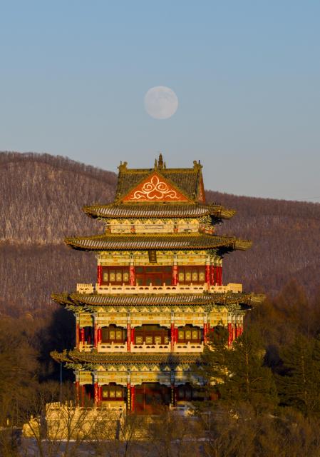 (251204) -- BEIJING, Dec. 4, 2025 (Xinhua) -- A drone photo taken on Dec. 4, 2025 shows a full moon over a tower in Shuangyashan City, northeast China's Heilongjiang Province. This year's second-largest full moon to the eyes of lunar observers will appear on Friday morning, but the best viewing time falls on Thursday evening. (Photo by Han Yang/Xinhua)