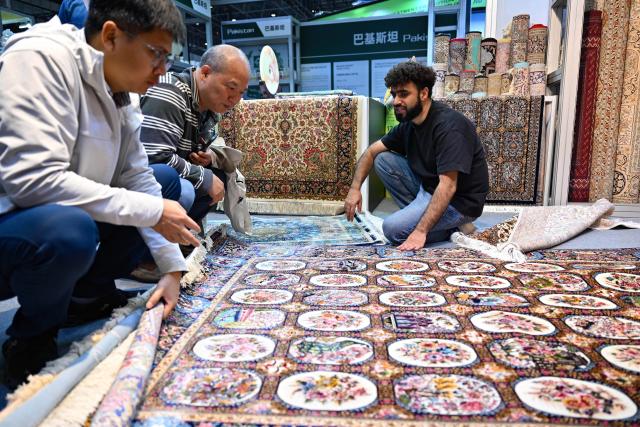 (251204) -- HAIKOU, Dec. 4, 2025 (Xinhua) -- Visitors learn about Pakistani carpets at the 28th China (Hainan) International Winter Trade Fair for Tropical Agricultural Products in Haikou, south China's Hainan Province, Dec. 4, 2025. The trade fair opened here on Thursday. (Xinhua/Guo Cheng)