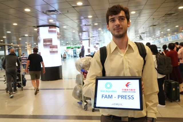 (251205) -- BUENOS AIRES, Dec. 5, 2025 (Xinhua) -- A staff member welcomes passengers arrived with the first direct air route between China and Argentina at Ezeiza International Airport in Buenos Aires, Argentina, Dec. 4, 2025. China Eastern Airlines' flight MU745 touched down in Buenos Aires, the capital of Argentina, on Thursday afternoon, marking the official launch of the first direct air route between China and Argentina, according to the carrier. (Xinhua/Zhang Duo)