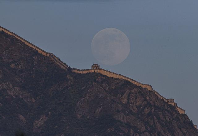 (251205) -- BEIJING, Dec. 5, 2025 (Xinhua) -- A full moon is pictured over a mountain in Yongjia County, Wenzhou City, east China's Zhejiang Province, Dec. 4, 2025. (Photo by Su Qiaojiang/Xinhua)